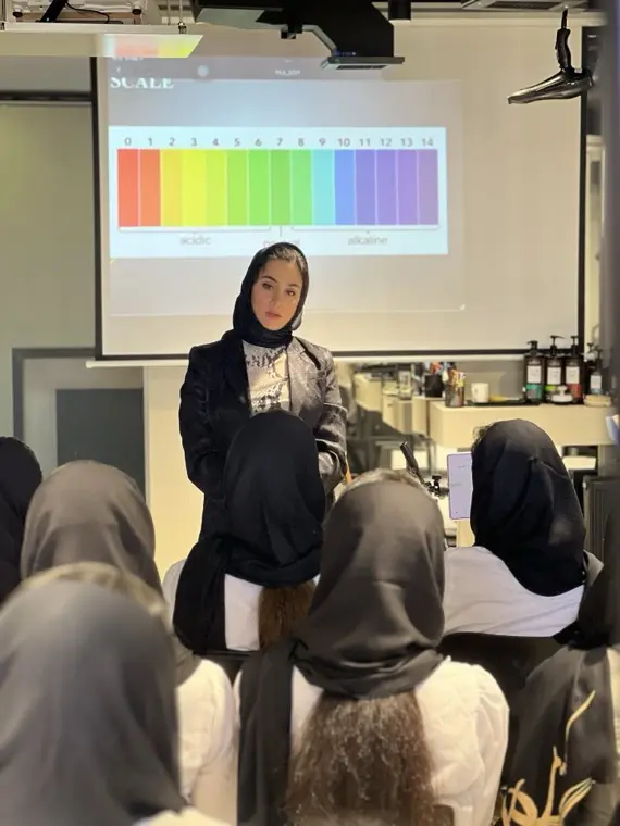کلاس تخصصی رنگ مو؛ مربی جلوی چارت درجهٔ رنگ